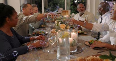 Pouring White Wine During Candlelit Family Dinner Sharing Salads and Toasting Together
