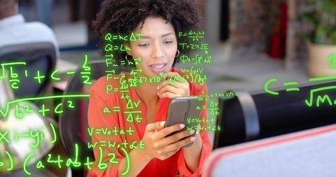 Curly-haired woman calculating math on smartphone in modern open-plan coworking space