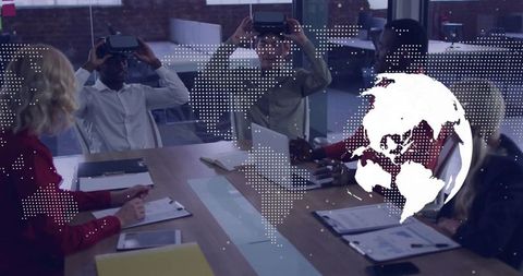 Diverse team testing virtual reality headsets around boardroom table with digital globe