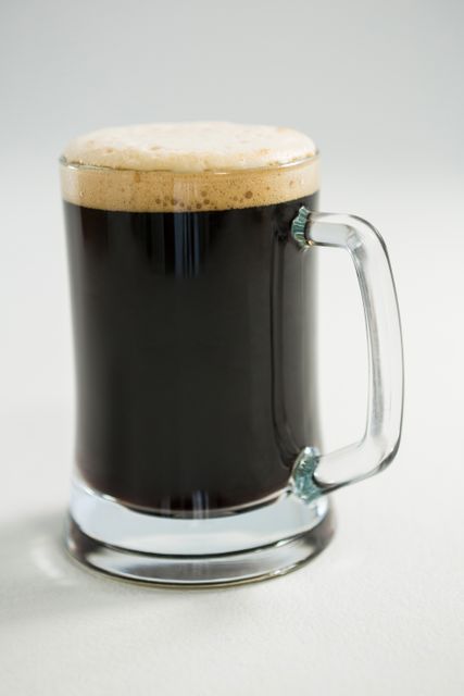 Close-up of black beer on white background