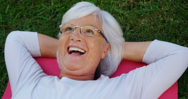 Happy Elderly Woman Relaxing on Grass Outdoors - Download Free Stock Images Pikwizard.com