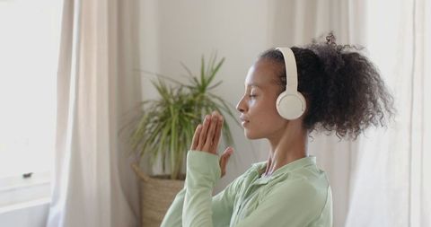 Focused Woman Meditating Indoors with Headphones