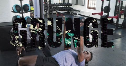 Spotter coaching athlete pressing dumbbells on bench during strength training session