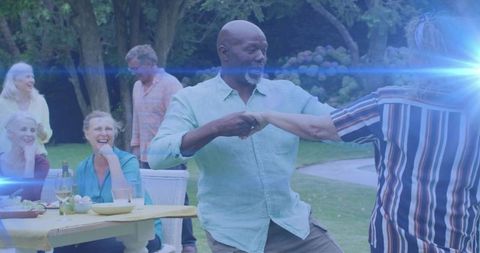 Senior couple enjoying outdoor dance at garden picnic