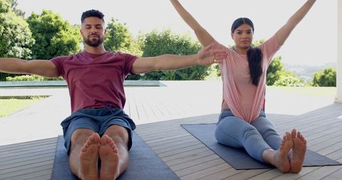 Fitness Enthusiasts Practicing Yoga Outdoors in Garden Setting