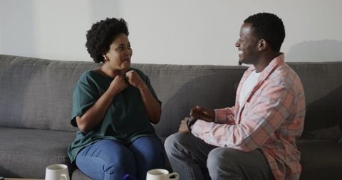 Excited woman receiving marriage proposal on sofa