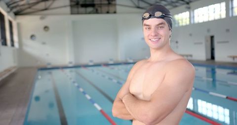 Confident male swimmer by indoor pool