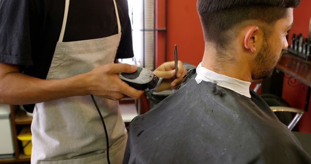 Barber giving a haircut to a client in a salon. Precision and care are evident as the barber styles the young man's hair.