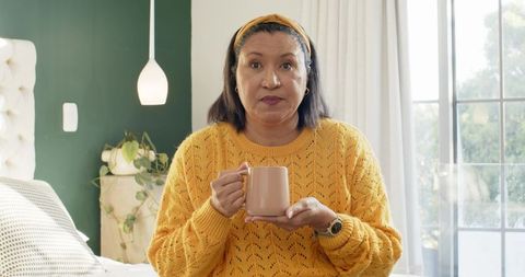 Woman Enjoying Coffee in Cozy Bedroom in Mustard Yellow Sweater