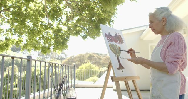 Senior Woman Painting on Canvas in Sunlit Outdoor Patio - Download Free Stock Images Pikwizard.com