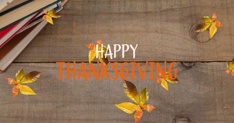 Happy Thanksgiving Message with Autumn Leaves on Wooden Background