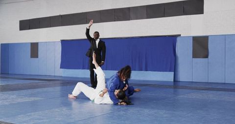 Teenage Female Athletes Grappling in Martial Arts Competition on Mats