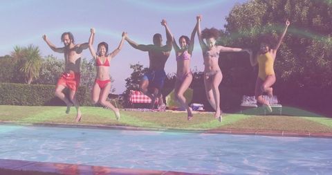 Group of friends joyfully jumping into backyard pool