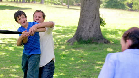 Joyful family enjoying baseball playtime in countryside