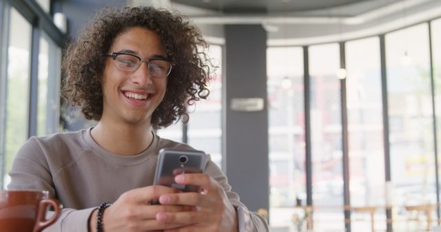 Happy Young Man Using Smartphone at Cafe with Bright Windows - Download Free Stock Images Pikwizard.com