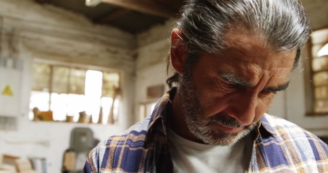 Pensive Mature Man in Plaid Shirt in Workshop - Download Free Stock Images Pikwizard.com