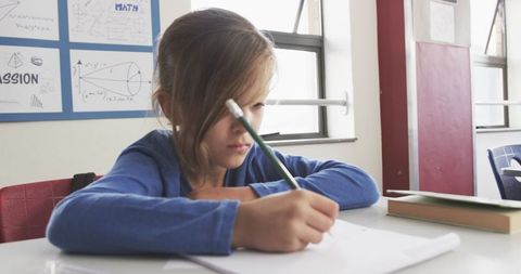 young student focused on homework in classroom - Download Free Stock Images Pikwizard.com