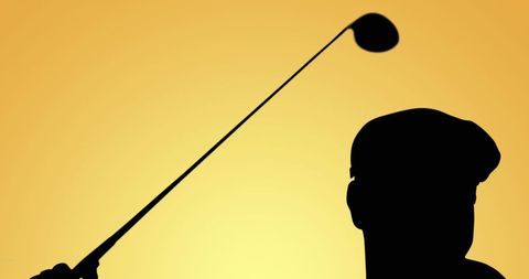 Silhouette of Golfer Spinning Iron Club at Sunset