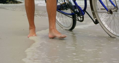 Man Walking Bicycle on Idyllic Sandy Beach