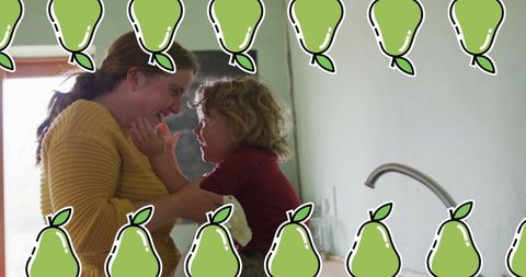 Playful mother and son in kitchen with pear digital overlay