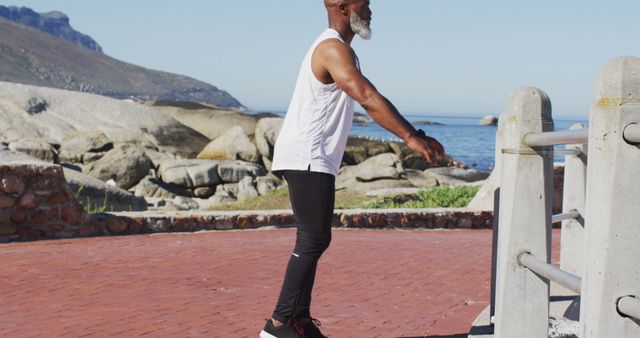 Fit Elderly Man Doing Outdoor Stretching Exercise in Scenic Coastal Area - Download Free Stock Images Pikwizard.com