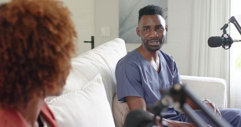 Medical professional podcasting from home studio in scrubs during casual interview