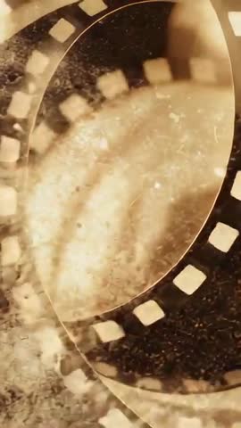 Rotating Vintage Film Strip Rings Vertical Video with Grainy Retro Texture and Moody Light