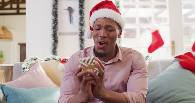 Portrait of happy african american man with santa hat having image call. Spending quality time at christmas alone concept.