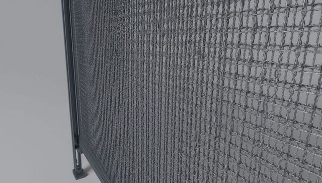 Close-up chain-link fence panel leaning on frame revealing mounting plate and bolt