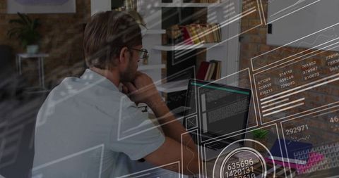 Man leaning at laptop studying code with futuristic HUD data overlays in home office