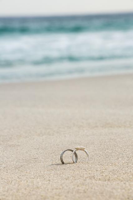 Wedding rings on sand at beach