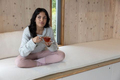 Woman Relaxing at Home with Tea in Cozy Minimalist Space