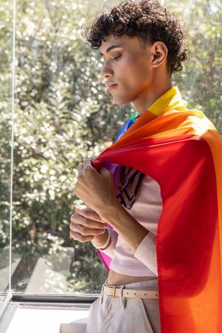 Young Man Embracing Pride in Sunlit Room