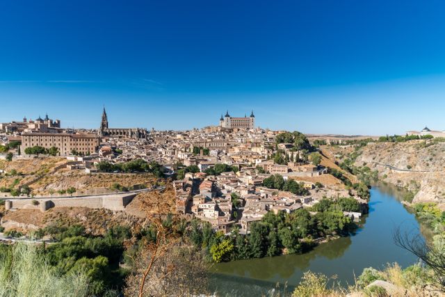 Beautiful panoramic view of Toledo with the River Tagus flowing through. This image highlights the historical architecture and sprawling cityscape of Toledo, renowned for its heritage and UNESCO World Heritage Sites. Ideal for use in travel blogs, tourism brochures, promotional material for travel agencies, and educational content about historical cities.