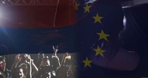 Backlit singer silhouette performing to packed crowd with eu flag overlay and stage lights