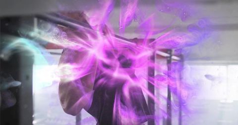 Man holding smartphone facing mirror with neon purple smoke, futuristic energy glow