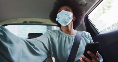 African American Female Business Professional Using Smartphone in Car