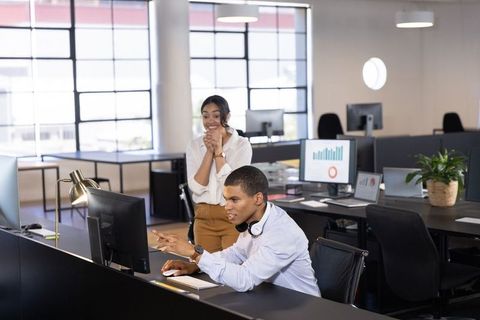 Coworkers Collaborating on Project in Modern Open-Plan Office
