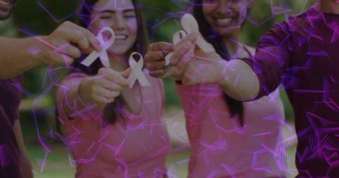 Volunteers wearing pink holding white ribbons for awareness with purple geometric overlay