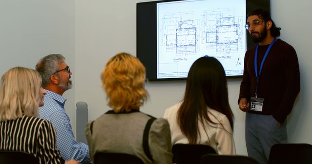 Architect Presents Building Plans at Office Meeting - Download Free Stock Images Pikwizard.com