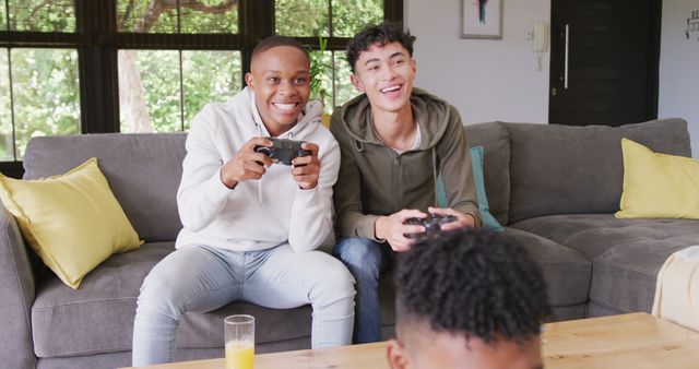 Two Young Men Enthusiastically Playing Video Games on Couch - Download Free Stock Images Pikwizard.com