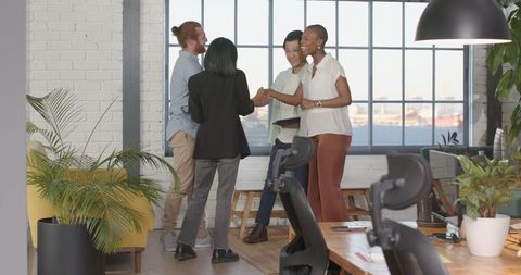 Diverse office team celebrating success with high-fives