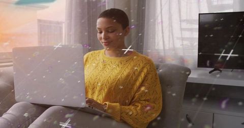 Woman working remotely on laptop in cozy armchair with soft light and minimalist interior
