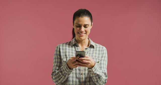 Smiling Woman Texting on Smartphone with Pink Background - Download Free Stock Images Pikwizard.com