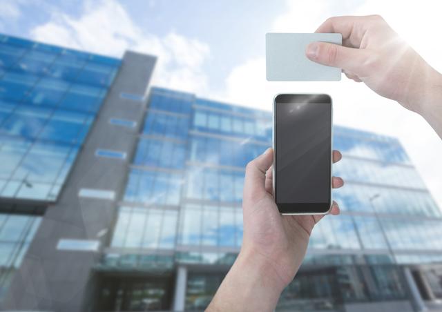 Hands holding a smartphone and access card in front of a sleek modern office building under a clear sky. The combined use suggests electronic access control, digitization, and secure entry systems. Perfect for articles or websites discussing business security, modern technology in workplaces, access control systems, or office environment overviews. The image conveys a sense of professionalism and advanced security measures.