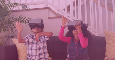 African american siblings exploring with vr headsets indoors