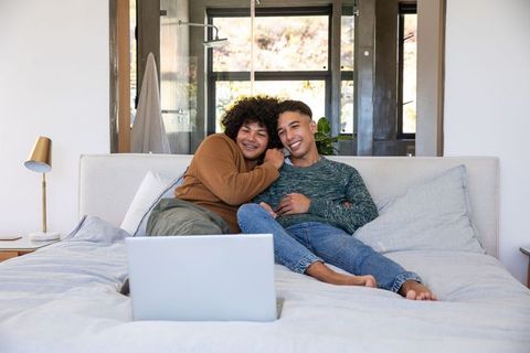 Couple Relaxing at Home Watching Laptop in Cozy Bedroom