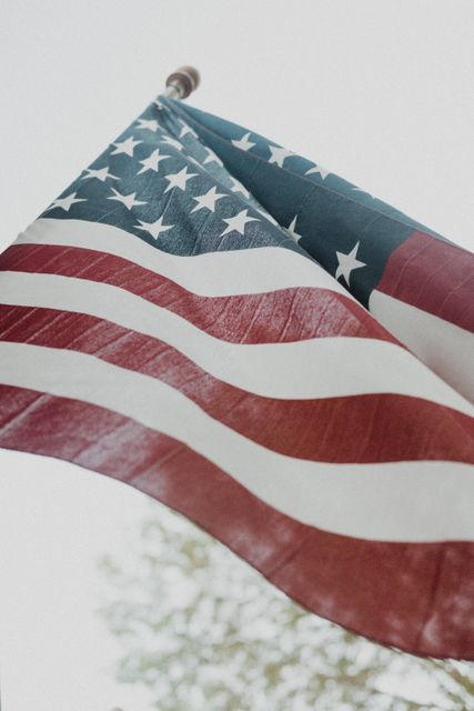 Close-up of the American flag waving outdoors during the daytime, showcasing the stars and stripes and symbolizing patriotism and national pride. Ideal for use in materials celebrating national holidays like Independence Day, Memorial Day, or Veterans Day, as well as for educational materials and political campaigns.