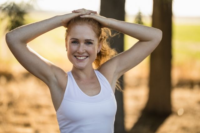 Portrait of smiling young woman exercising on sunny day at farm