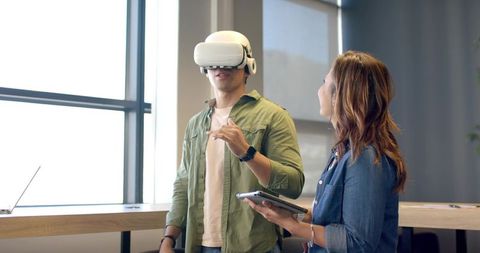 Team Exploring Virtual Reality in Office Collaboration Demonstrating VR Headset and Tablet